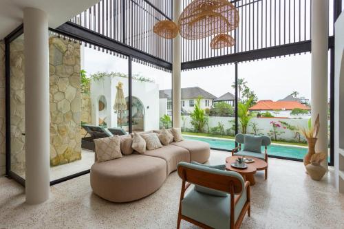 a large living room with a couch and chairs at Villa Oria Canggu - Brand new 3BR mediterranean Villa with Ricefield sunset view in Kerobokan