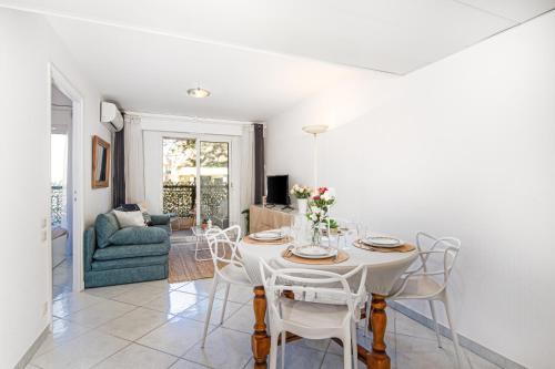 une salle à manger blanche avec une table et des chaises dans l'établissement DATURAS - Agréable 2 pièces - Proche Mer - Menton Centre, à Menton