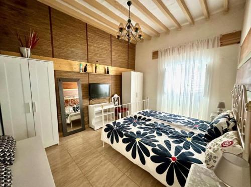 a bedroom with a bed with a blue and white comforter at Casa Estrada in Caleta de Interián
