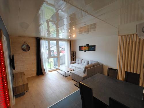 una sala de estar con un sofá y una mesa en Appartement Balnéo vue sur cascade, en Saulxures-sur-Moselotte
