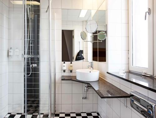 a bathroom with a sink and a shower at Scandic Stortorget in Malmö