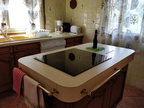 une cuisine avec un évier et une bouteille sur un comptoir dans l'établissement Nice, appartement 3 pièces à 500m des plages, à La Celle-sous-Gouzon