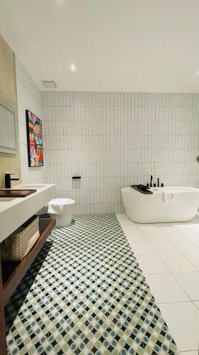 a bathroom with a tub and a toilet and a sink at BaBa Boutique House Langkawi in Pantai Cenang