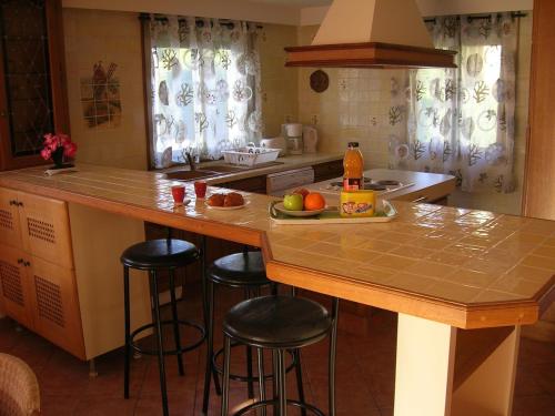 - une cuisine avec un îlot avec des tabourets de bar et des fruits dans l'établissement Nice, appartement 3 pièces à 500m des plages, à La Celle-sous-Gouzon