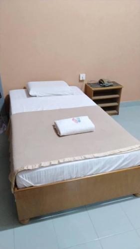 a bedroom with a bed with a towel on it at Susan Hotel Seafront in Sandakan
