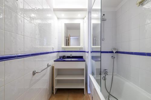 une salle de bain blanche avec un lavabo et une douche dans l'établissement 904 - Rooftop in city center, beach 100m away, à Menton