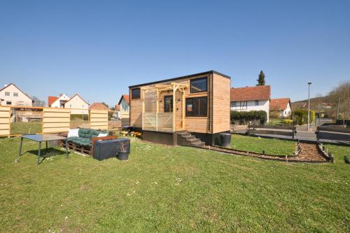 a tiny house sitting on top of a grass field at Tiny House Rhön- Natur & Komfort in Buttlar