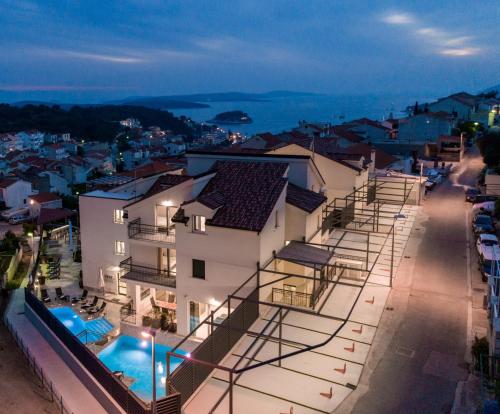 a large white building with a swimming pool at night at Hotel - Teranea City Hvar in Hvar