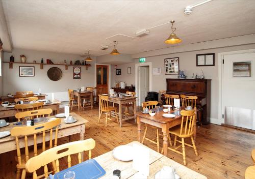 a dining room with wooden tables and chairs at Woodstock Arms - Bar, Bed & Breakfast in Inistioge