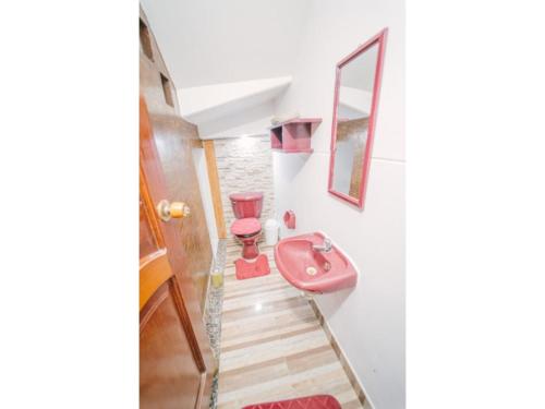 a bathroom with a pink sink on the wall at Departamento amoblado de 3 habitaciones tarapoto in Tarapoto