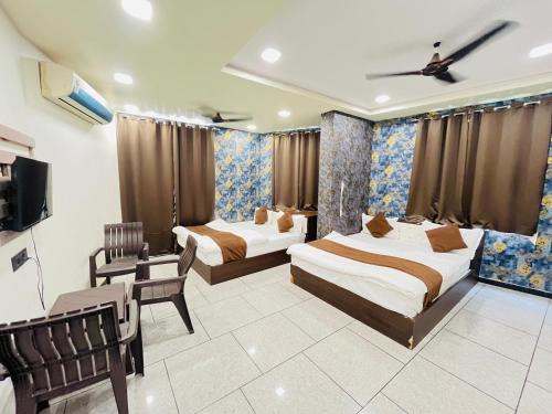 a hotel room with two beds and a tv at Hotel Shree Vijay I g66ogoIoo6 just 100mtr from temple 1min away in Nāthdwāra