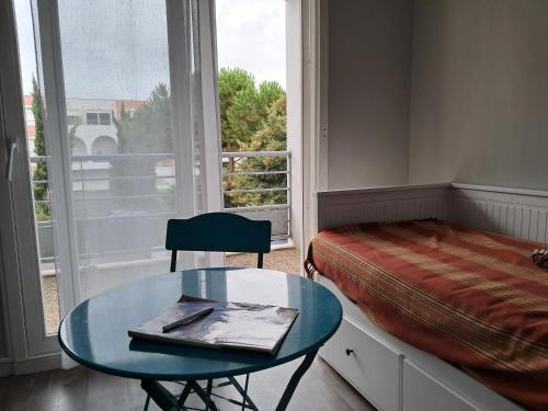 une chambre avec un lit, une table et une fenêtre dans l'établissement résidentiel, à La Rochelle