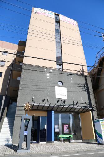 a building with a sign in front of it at Hotel Plaza Arakawaoki in Tsuchiura