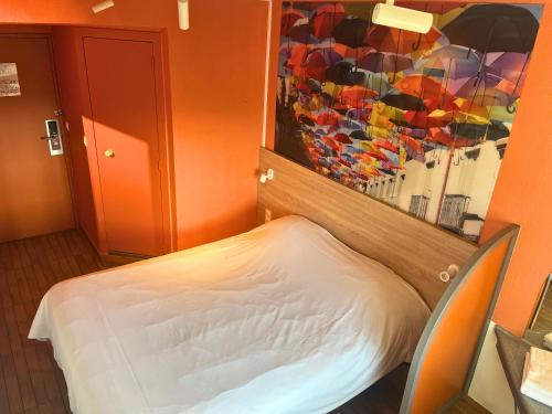 a room with a bed and a mirror with umbrellas at Egg Hôtel Sarcelles in Sarcelles