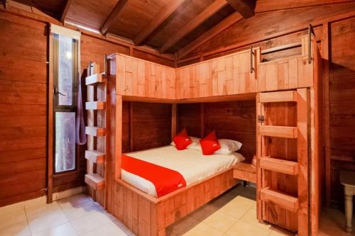 a bedroom with a bunk bed with red pillows at Capital O Hacienda Filadelfia, El Atorón, Irapuato in Irapuato