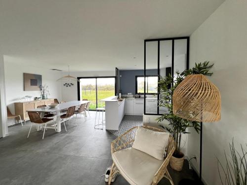 a living room and kitchen with a table and chairs at Villa de l'Ile d'Olonne in LʼÎle-dʼOlonne