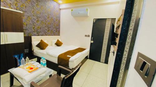 a small room with a bed and a small table at Hotel Shree Vijay I g66ogoIoo6 just 100mtr from temple 1min away in Nāthdwāra