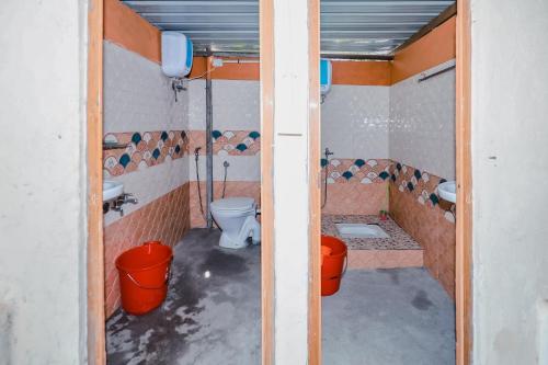 a bathroom with a toilet and a sink and buckets at Aishwarya Heritage Villa in Vattavada