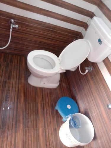 a bathroom with a toilet and a blue scale at Swami's Yatri nivas in Akalkot