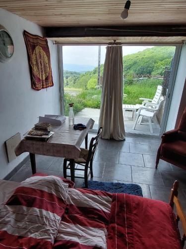une chambre avec une table et une vue sur un patio dans l'établissement chambre basique, endroit magique, à La Renaudie