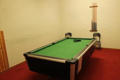 a pool table in a room with two chairs at La Trinitè Monboso Hotel in Gressoney-la-Trinité