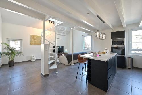 une cuisine et un salon avec un escalier dans une maison dans l'établissement Le Pamela - Appt climatisé, à Aix-les-Bains