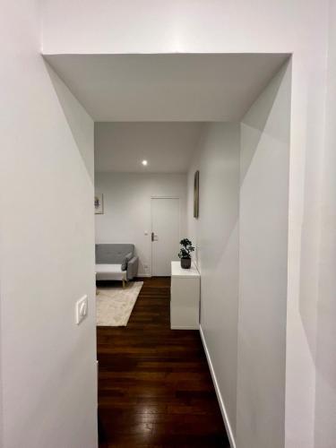 - un salon avec des murs blancs et du parquet dans l'établissement COSY IVRY charmant 2 pièces aux portes de Paris, à Ivry-sur-Seine
