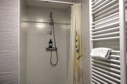 une salle de bain avec une douche avec un rideau de douche dans l'établissement Couleur Pyla - Avec piscine partagée, à La Teste-de-Buch