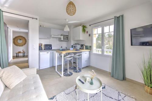 une cuisine et un salon avec un canapé et une table dans l'établissement Couleur Pyla - Avec piscine partagée, à La Teste-de-Buch