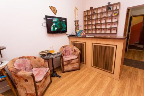 a living room with two chairs and a table and a tv at Motel Edem in Mostar