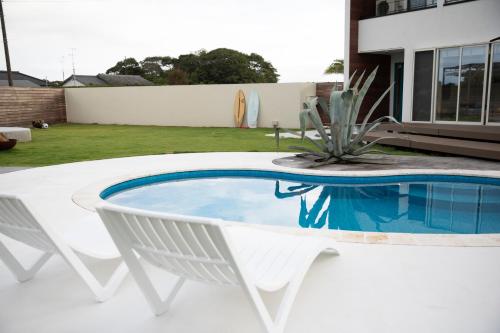 a white chair and a swimming pool in a yard at VILLA Seamu 海風とどく広々贅沢GARDEN エアコン付きBBQルームを備えた高級ヴィラ in Kujukuri