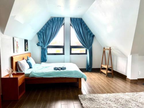 une chambre avec un lit, des rideaux bleus et une fenêtre dans l'établissement Villa &Coffee Garden, à Xuan An