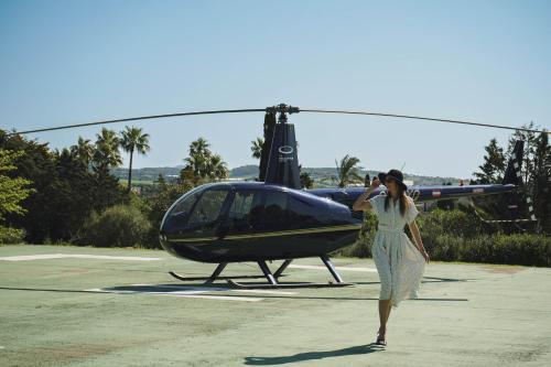 a woman in a dress walking towards a helicopter at Reserva Rotana Golf Resort in Manacor
