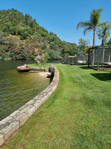 a small boat is docked in a river at Douro Suites in Riba Douro