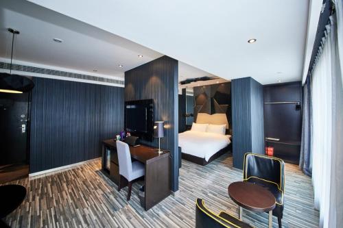 a hotel room with a bed and a desk at Orange Hotel Shanghai Hongkou Football Stadium Branch in Shanghai