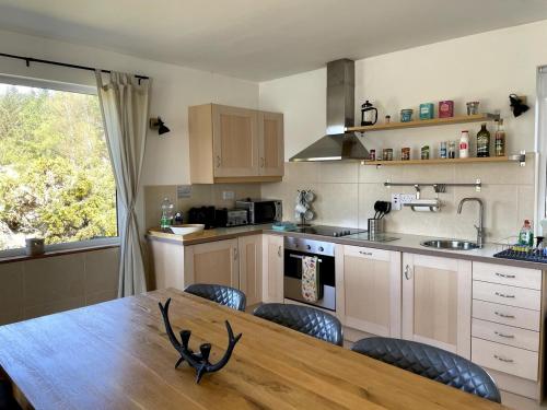 a kitchen with a wooden table with chairs and a dining room at Lake House Lough Atorick in Pollavogo