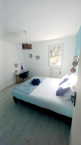 a large bed in a white room with a table at Gîte Gournier's Sweet Home in Bas-en-Basset