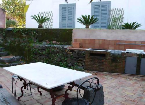 a table and chairs in a backyard with a brick wall at Case Zuccaro in Trecastagni