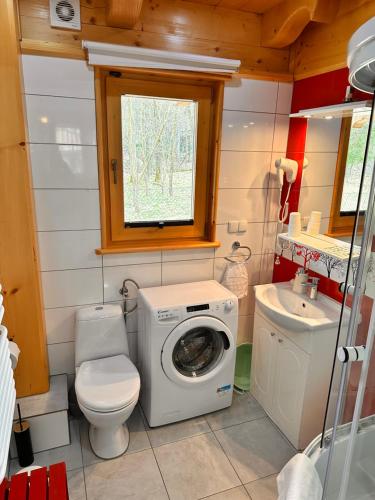 a small bathroom with a washing machine and a sink at Domki u Magdy in Zakopane