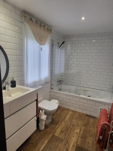 a bathroom with a tub and a toilet and a sink at El Remanso casa para desconectar in Aldea del Fresno