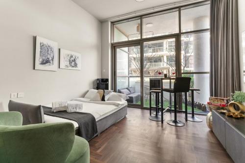a living room with a bed and a large window at FIRST CLASS Studio Urban Hideaway in Dubai
