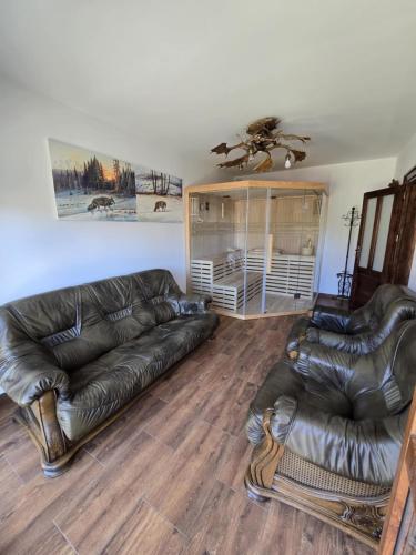 a living room with two leather couches and a table at BIESCZADNIK in Polańczyk