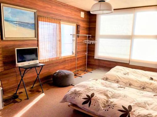 a bedroom with a bed and a desk with a television at COZY STAY ReCork 民泊リコルク 車1台駐車可 in Sapporo
