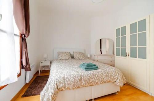 une chambre blanche avec un lit et une commode dans l'établissement Nouveau T2 Centre Historique, à Thiers