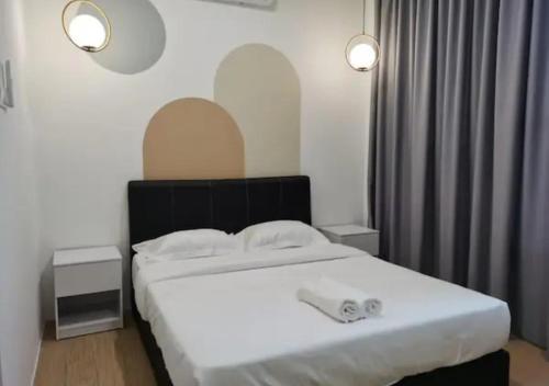 a bedroom with a large white bed with two lights at ITCC Manhattan by IGVC in Penampang