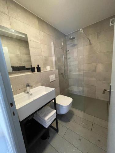 une salle de bain avec un lavabo, des toilettes et une douche dans l'établissement Les Remparts 1, à La Charité-sur-Loire