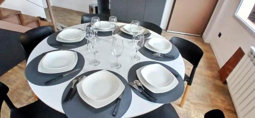 a white table with plates and wine glasses on it at Las Victorias Suites Bariloche in San Carlos de Bariloche