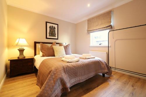 a bedroom with a bed with two towels on it at Signature - Cross House in Lanark