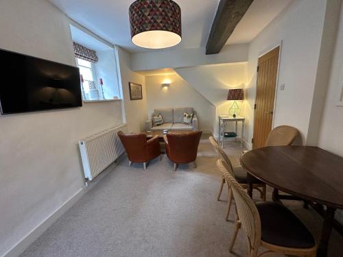 a dining room with a table and chairs and a television at The Yard House in Sherborne