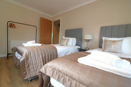 a hotel room with two beds and a mirror at Signature - Cross House in Lanark